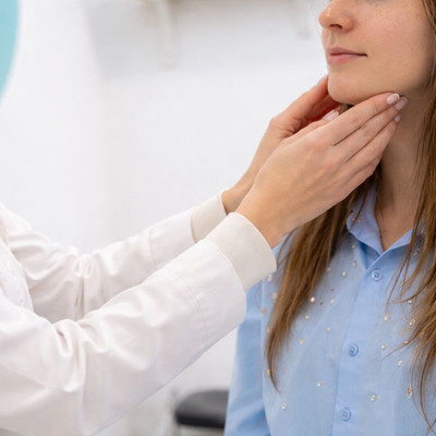 Aesthetic consultation at SolSkinn Medical Aesthetics, showing a provider’s hands assessing facial structure in a calm clinic setting.
